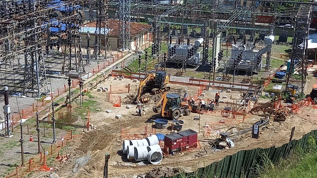 Retroescavadeiras e equipe em obra civil no pátio de uma subestação