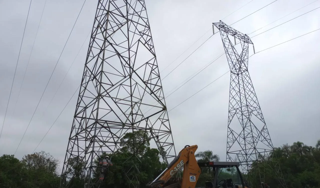 Retroescavadeira CASE trabalhando entre duas torres de linha de transmissão